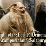 Horned white-fur demon with blood-streaked face leading performers during Krampuslauf Salzburg street parade