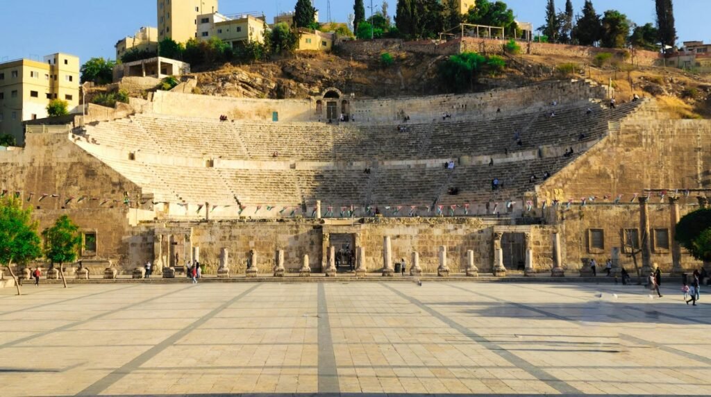The Hashemite Plaza in Amman, Jordan, with the ancient Roman amphitheater in the background and open stone-paved square in the foreground.