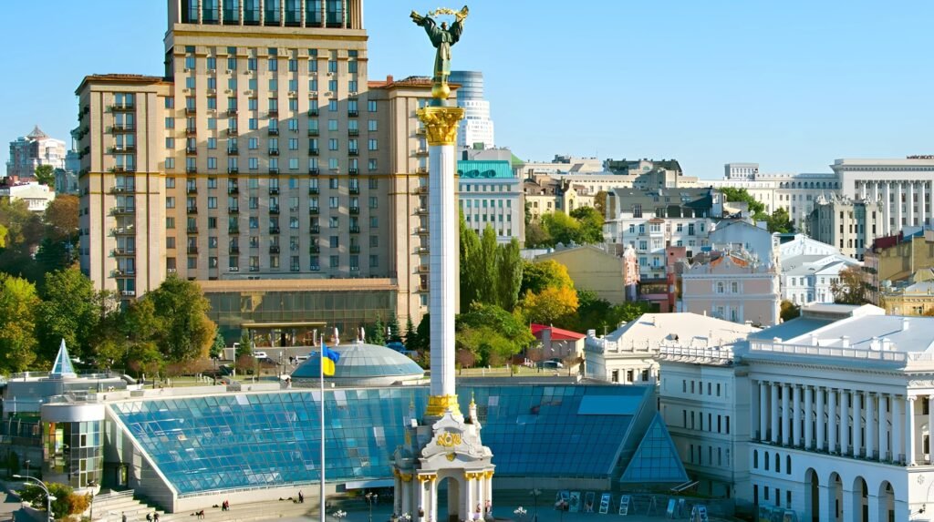 Iconic Public Squares: Independence Square in Kyiv, Ukraine, with the golden Archangel column rising above glass pavilions and surrounding historic buildings.