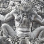 Close-up of the stone Triton sculpture, the iconic guardian of the Triton Gate Pena Palace in Sintra, featuring its fierce expression and intricate marine details.