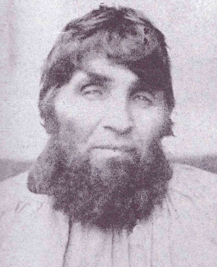 A vintage, monochrome portrait captures Martin Dumollard, a man with a thick, shaggy beard and dark, intense eyes.