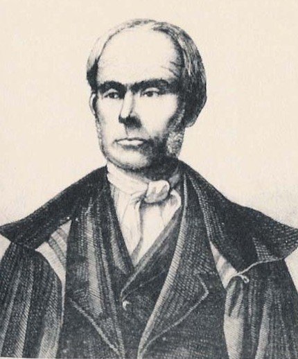 A monochrome portrait shows Antonio Boggia, a man with a receding hairline and serious expression, wearing a dark coat and cravat.