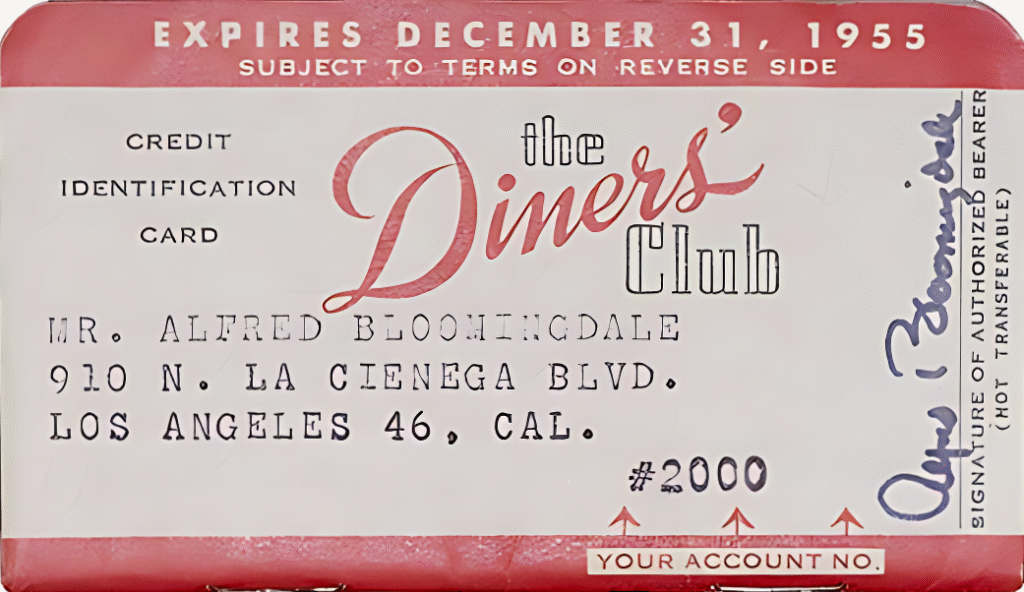 Vintage Diners Club card issued in 1955 showing member name, address, expiration date, and signature slot, illustrating the early charge card era.