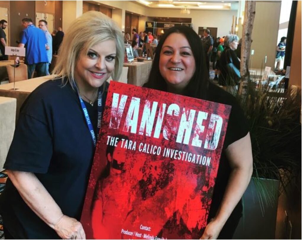 Two women at a public event hold a poster reading “Vanished: The Tara Calico Investigation,” showing community support for the unsolved mystery of the Tara Calico case.