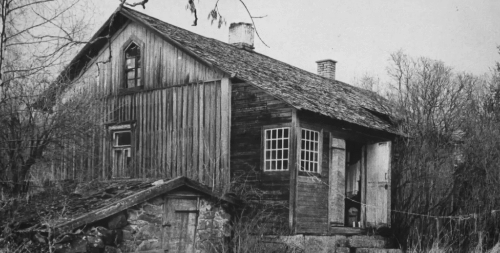 Black and white photo of the old wooden house in Kokemäki, Finland, where Hilkka Saarinen lived and was tragically murdered in the infamous 'Oven Murder' case.