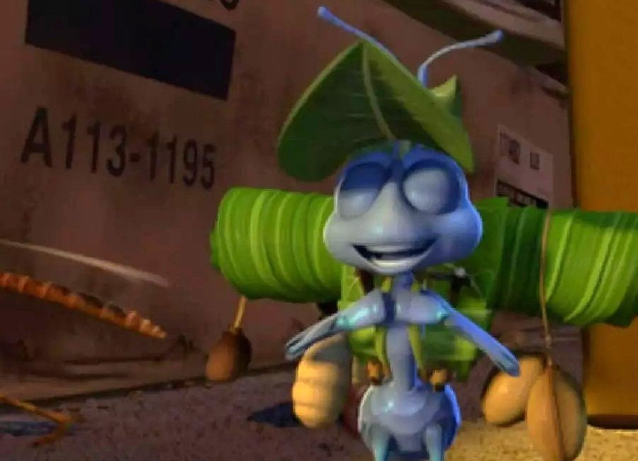 Flik from A Bug’s Life walking with a leaf hat, with the Pixar Easter egg “A113-1195” visible on the box in the background.